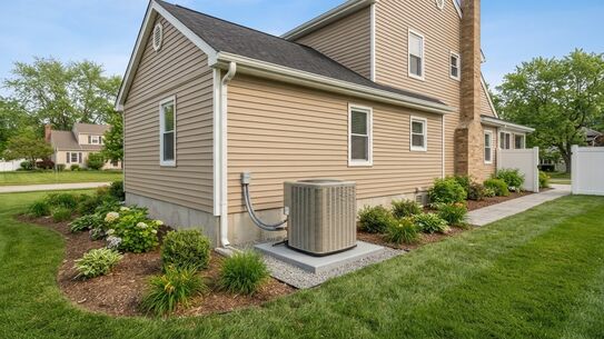 American home with a new air conditioner condenser unit installed at the side